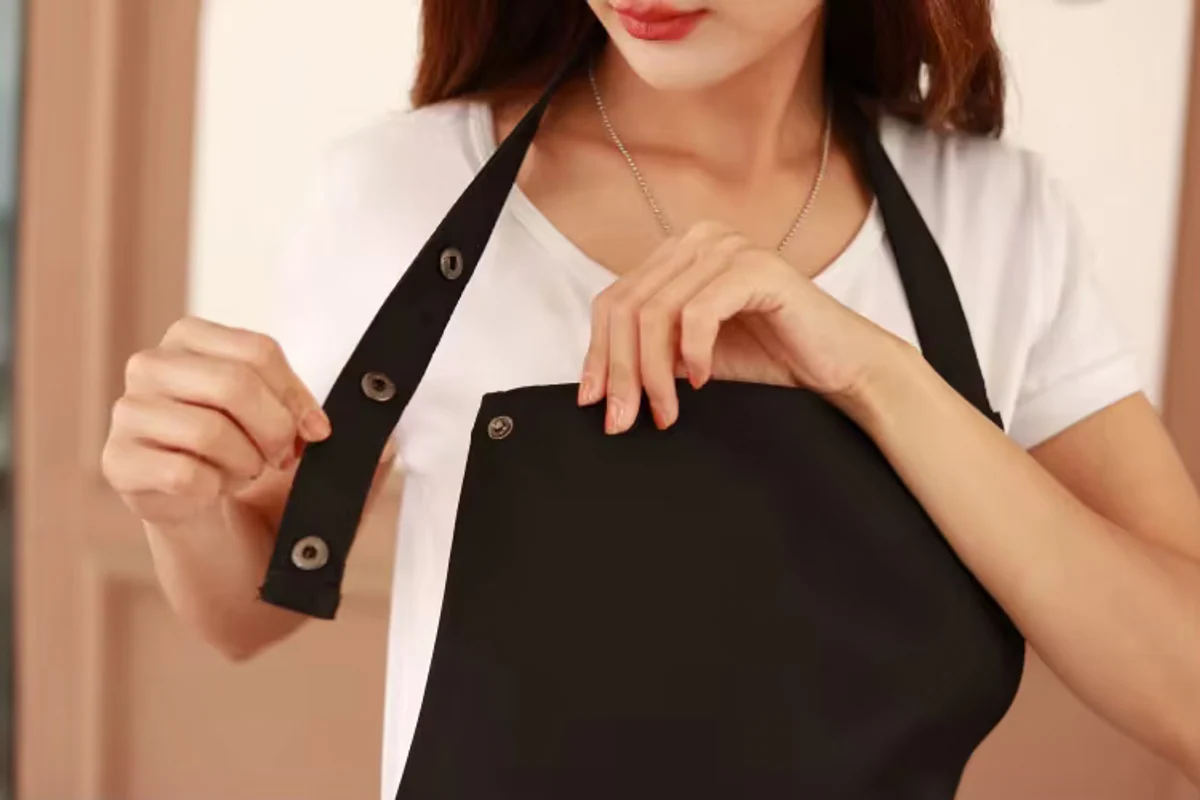 An apron neck strap with adjustable metal press studs.