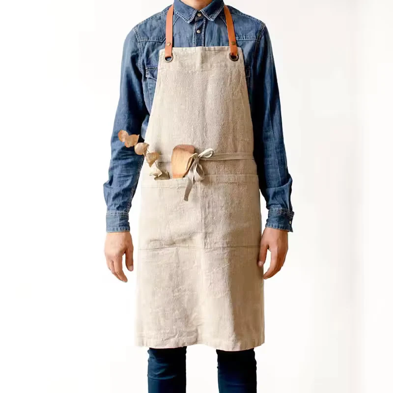 Cream bib apron worn over a blue shirt.
