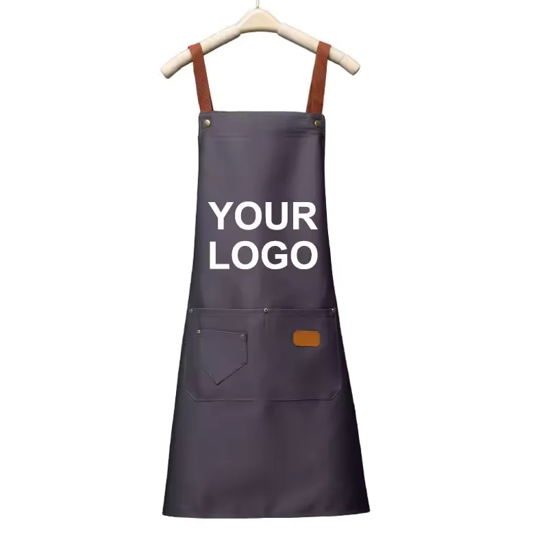 Dark gray apron with brown straps, front pockets, and white YOUR LOGO lettering.