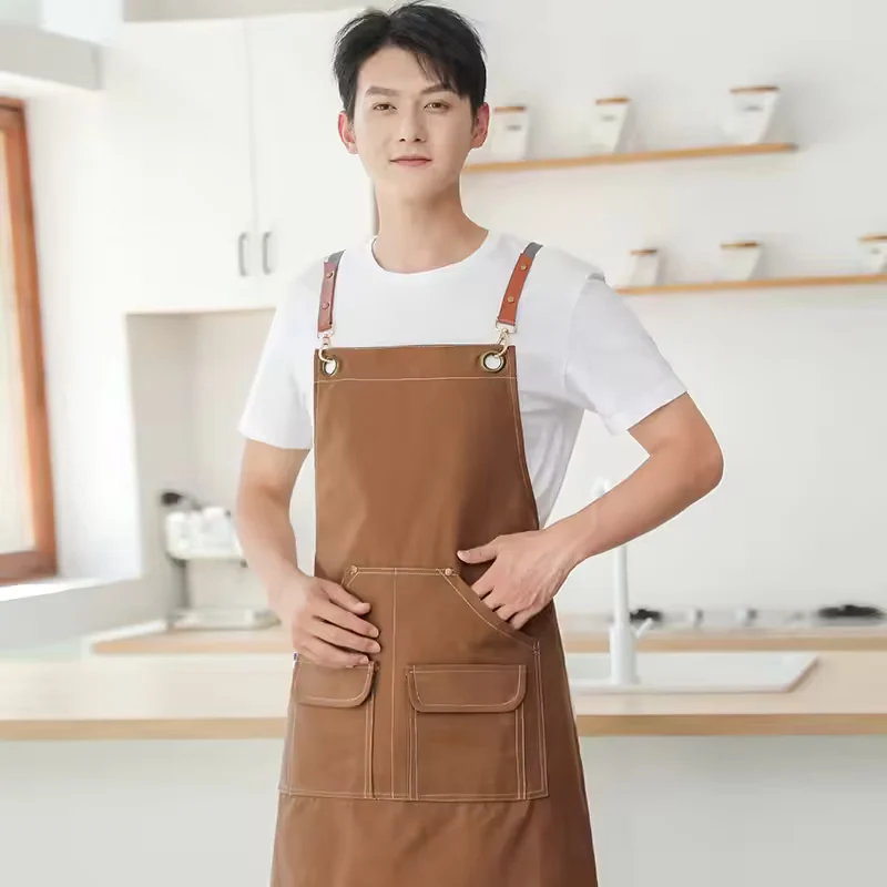 Brown apron with riveted strap attachments and front pockets.