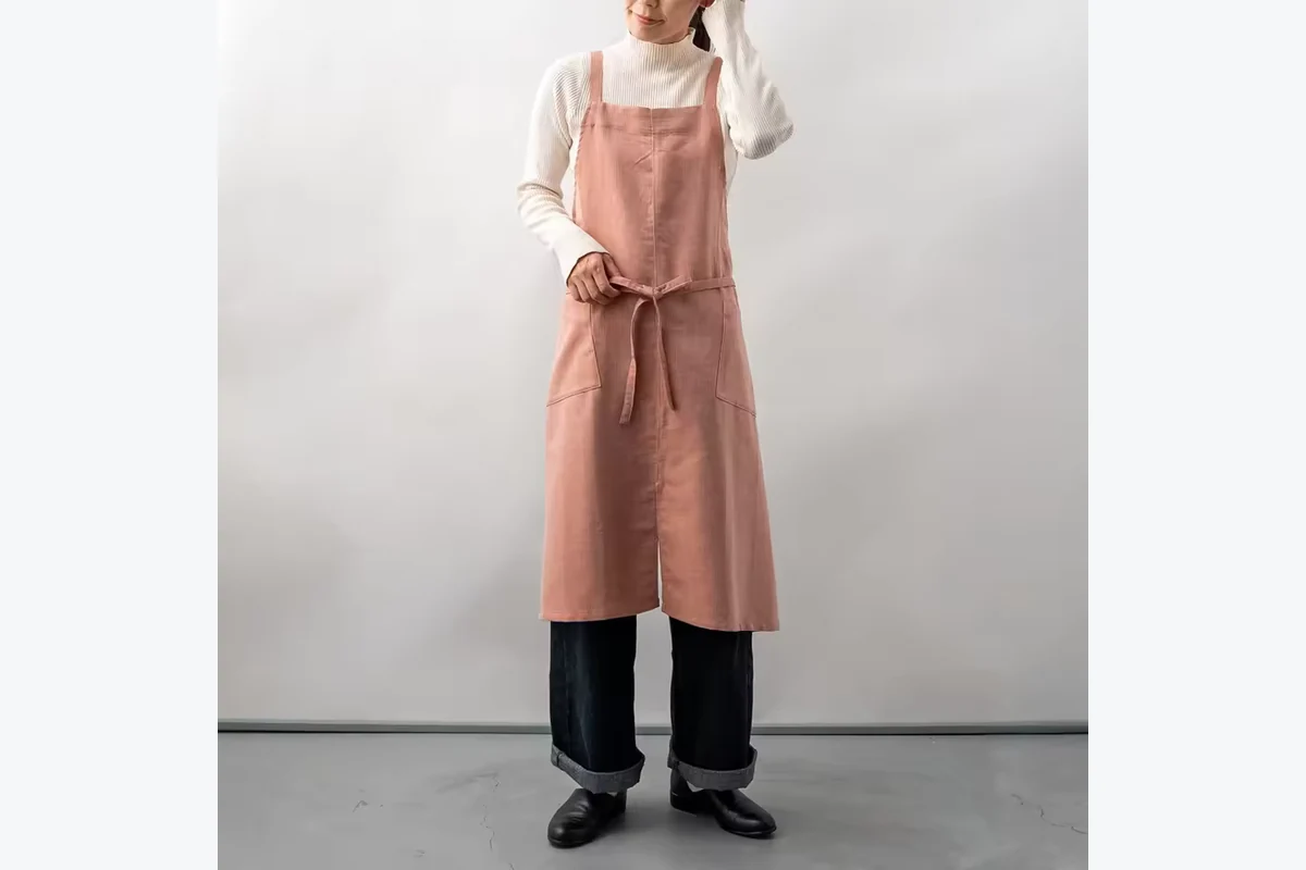 Long muted pink apron with a front waist tie.