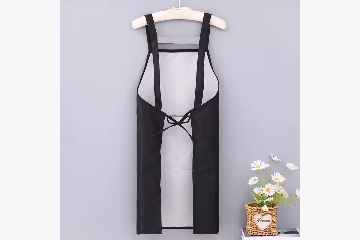 Back view of a black apron with parallel shoulder straps and waist ties.
