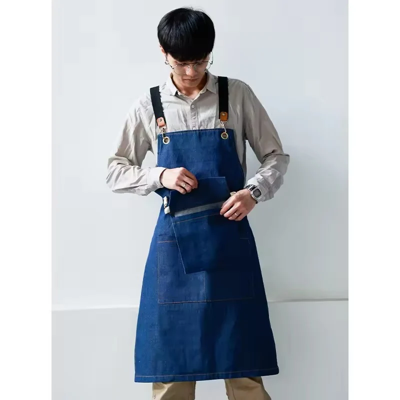 A blue denim apron worn over a light shirt.