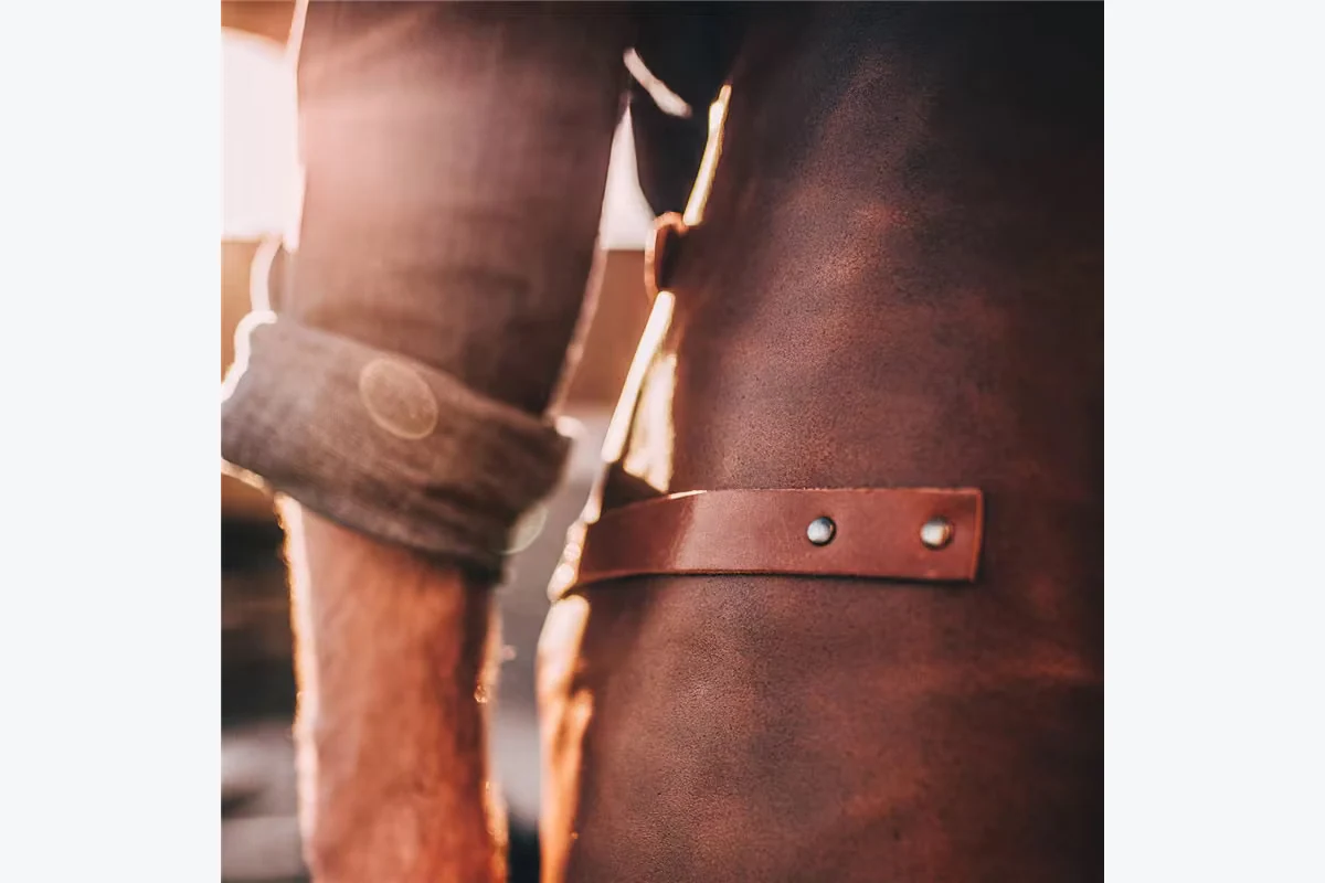 Brown apron surface with visible grain and a metal rivet.