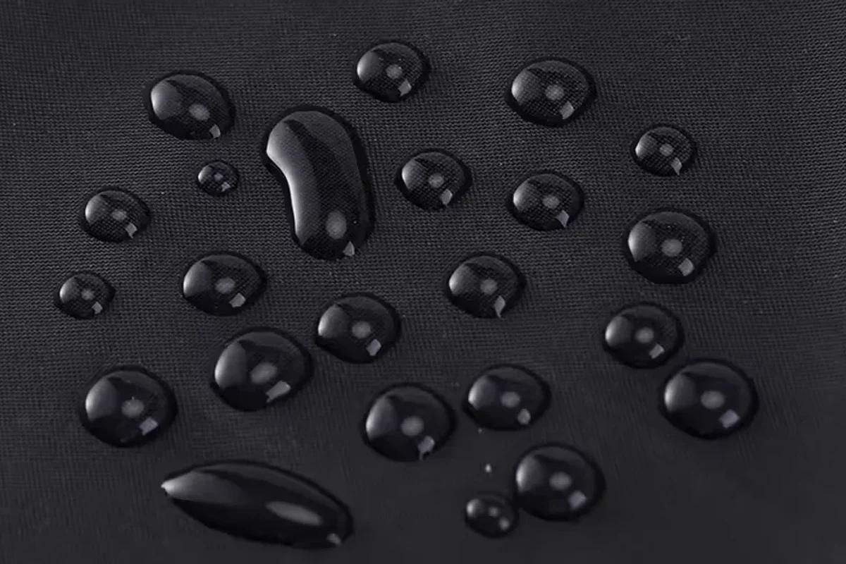 Water droplets resting on a dark apron surface.