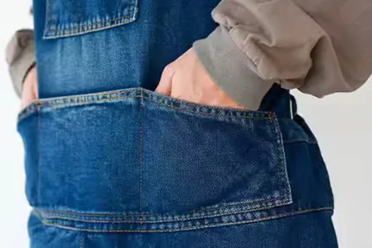 A denim apron pocket with visible seams.