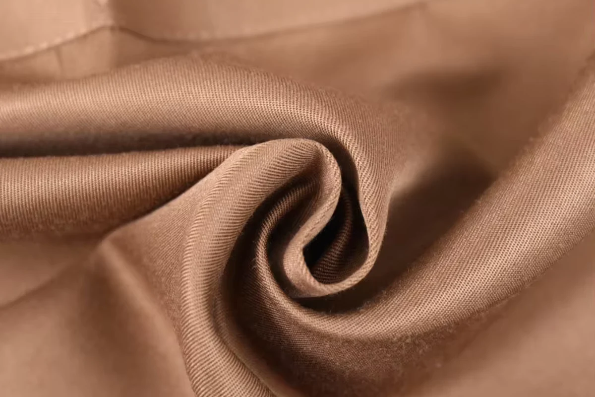 Smooth brown apron material arranged in folds.