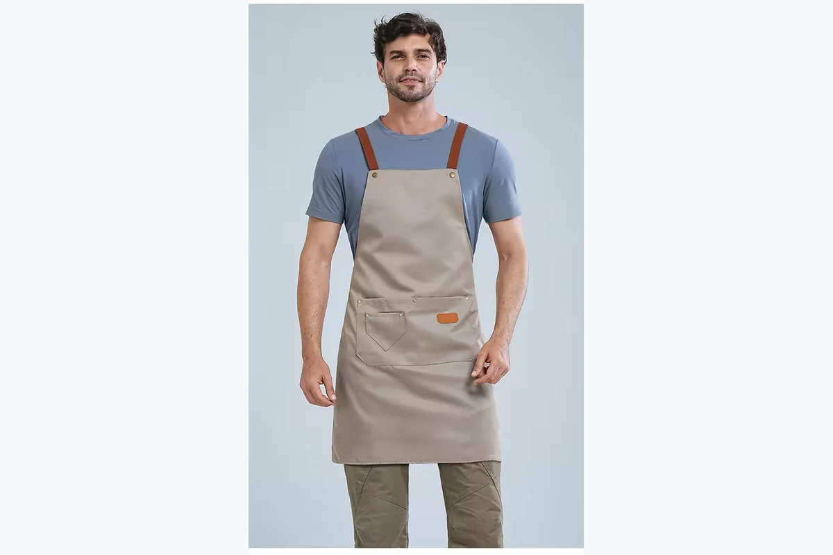A gray bib apron worn over a blue shirt.