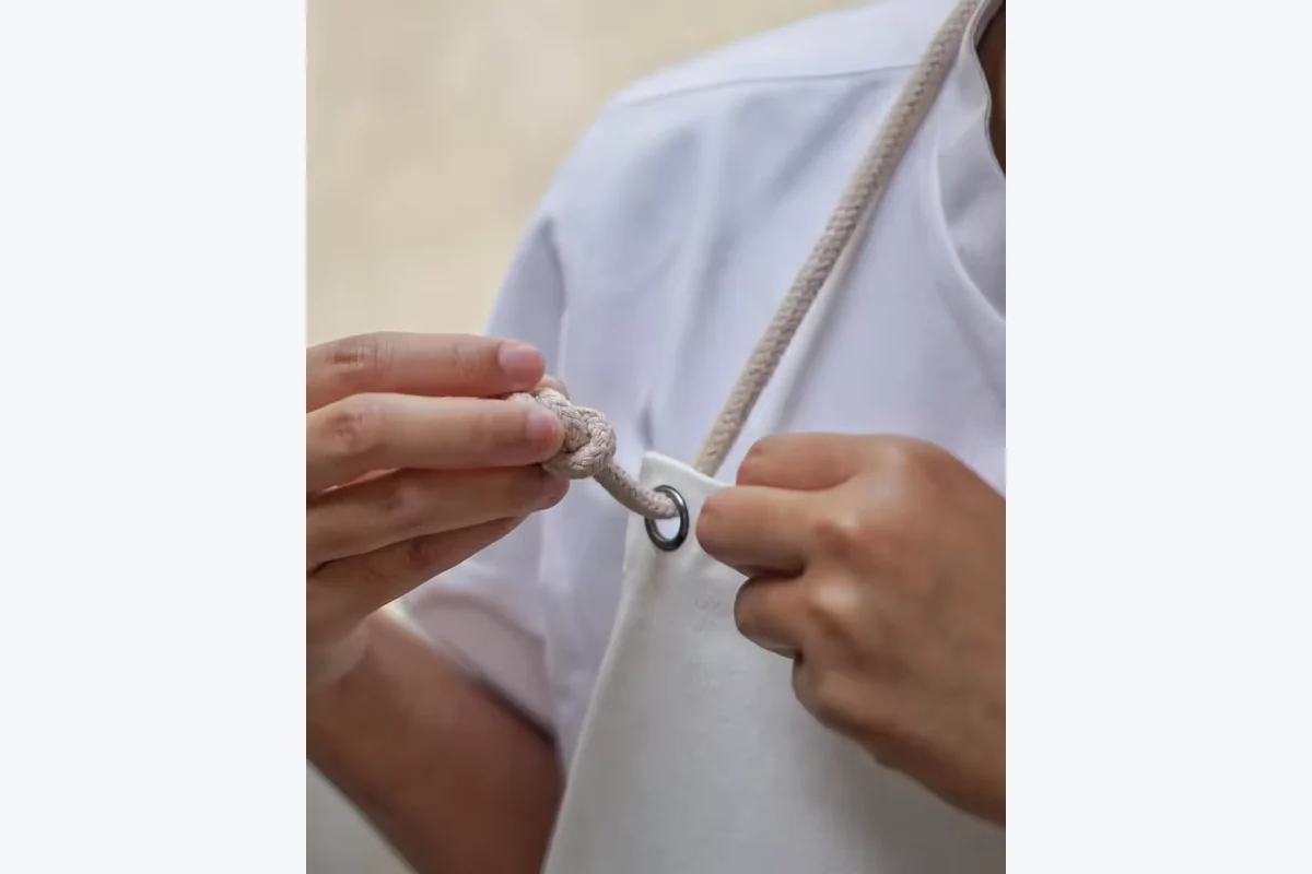 Hands checking the adjustable fastener on a light apron strap.